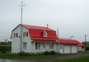 50 km vor Montreal, Provinz Quebec. Oft haben Häuser schrille Farben am Dach. Typischer Stil hier mit Garagen und einem Postkasten vor dem Haus.